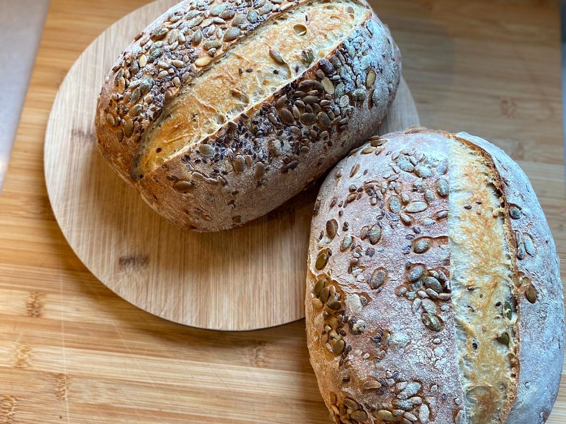 Seeded sourdough loaves on a wooden board